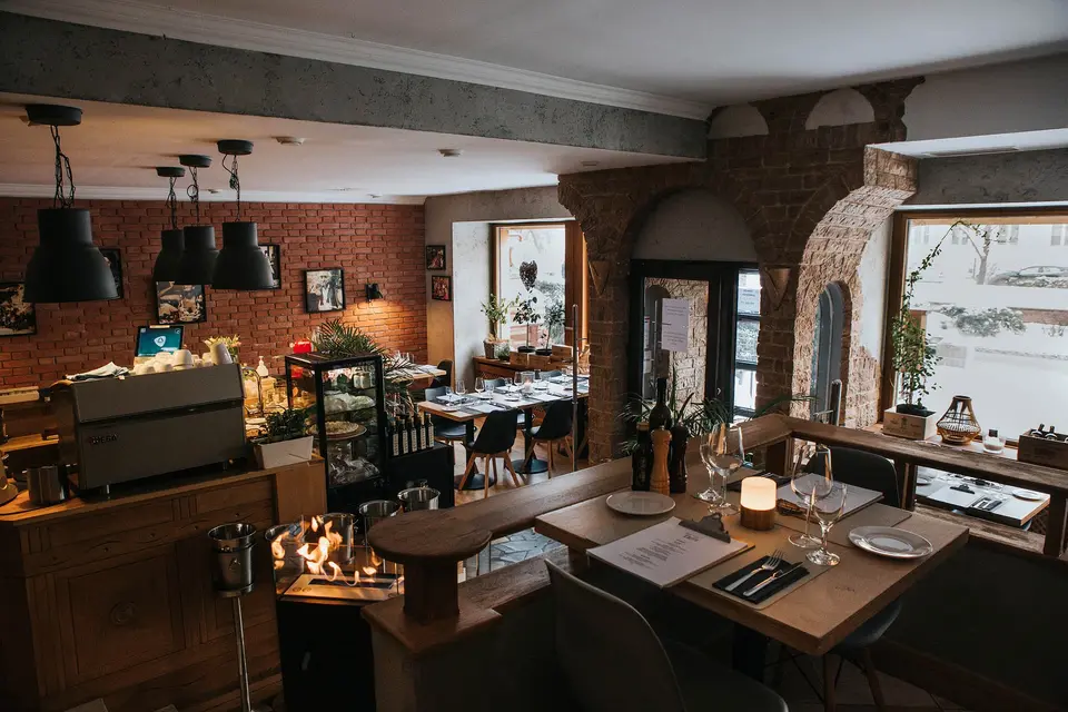 Wnętrze Restauracji Emilio — sala główna z włoskim ekspresem i ceglastymi łukami